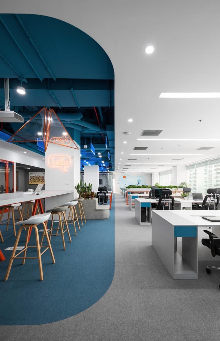 Helles, modernes Open-Space-Büro mit blauer Decke – Ausbau und Gestaltung von Commercial & Retail Immobilien.